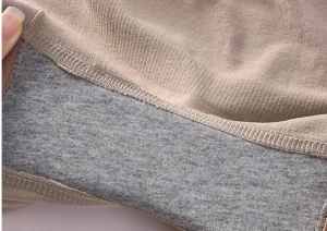 Close-up of soft beige and gray lingerie fabric, highlighting quality material and stitching.